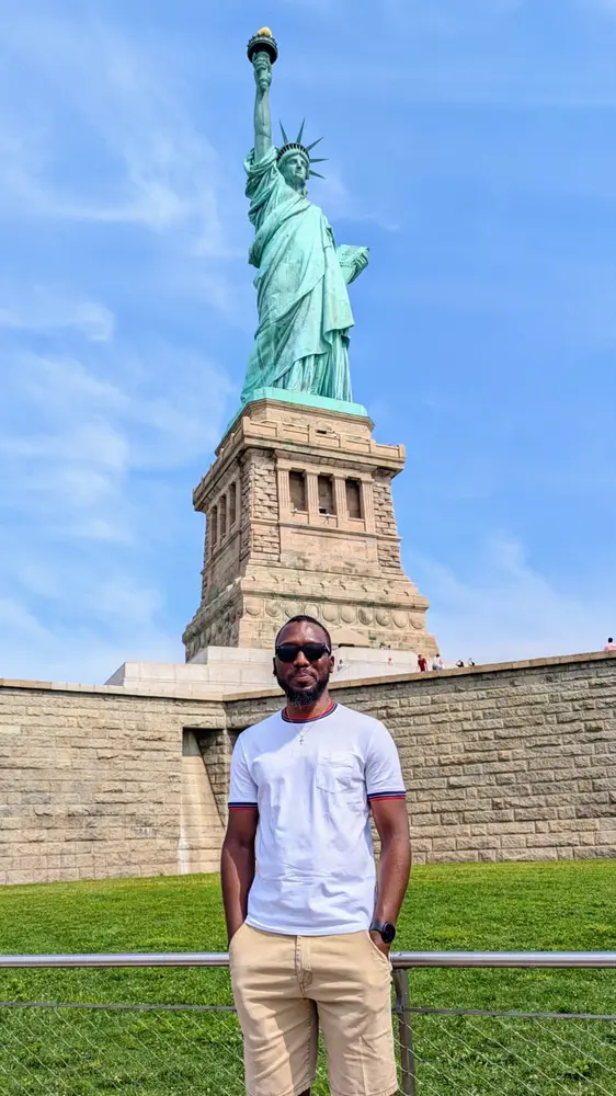 Membre de KadyJet devant la Statue de la Liberté à New York